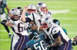  ?? Gregory Shamus Getty Images ?? TOM BRADY is stripped of the ball on the Patriots’ ensuing possession, giving the ball back to the Eagles, who stretched their lead to 41-33 with a field goal.