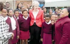  ?? — Reuters ?? Britain’s Prime Minister Theresa May poses for a picture with school children during a visit to the ID Mkhize Secondary School in Gugulethu near Cape Town, South Africa, on Tuesday.