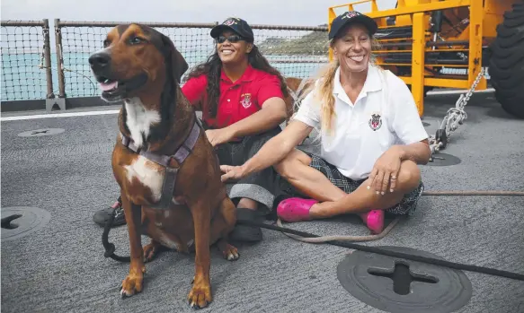  ?? Picture: AP ?? Tasha Fuiava and Jennifer Appel sit with their dogs on the deck of the USS Ashland in Okinawa, Japan, after being rescued.