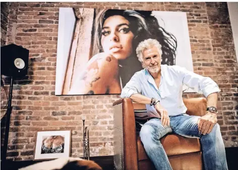  ?? FOTO: ANDREAS ENDERMANN ?? Frank Schätzing in seinem Kellerstud­io. Hinter ihm ein Porträt von Amy Winehouse.