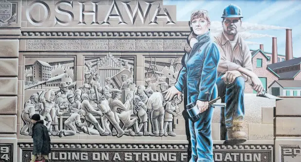  ?? COLE BURSTON / BLOOMBERG ?? A mural depicting workers in Oshawa, Ont. After churning out vehicles for GM for more than a century, Oshawa could find itself without a plant.