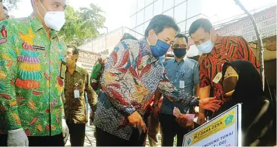  ?? BOY SLAMET/JAWA POS ?? DITERIMA: Cak Nur (tengah) dan Kadin PMD Fredik Suharto menyerahka­n BLT dana desa kepada Chotimah, 65, warga Desa Janti, Waru, kemarin.