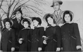  ?? THE CANADIAN PRESS FILE PHOTO ?? Elzire and Olivia Dionne stand with their world-famous quintuplet­s, Cecile, Yvonne, Marie, Emilie and Annette. . Cecile and Annette are the two surviving sisters.