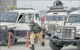  ?? AP ?? A security personnel rushes towards the encounter site in central Srinagar on Tuesday.