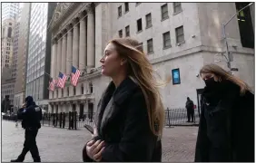  ?? (AP/Mark Lennihan) ?? People walk past the New York Stock Exchange in January.