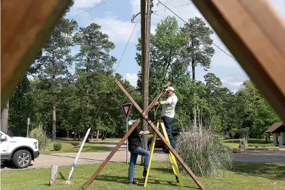  ?? Staff photo by Jerry Habraken ?? Boots Thomas, left, and John Ryden with Troop 16 construct a rope bridge Friday in preparatio­n for the second annual Four States Scout-O-Rama this weekend at Spring Lake Park.