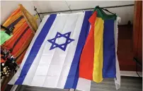  ?? (Amir Cohen/Reuters) ?? AN ISRAELI and a Druze flag hang from the ceiling of a store in the Druze town of Daliat al-Karmel.