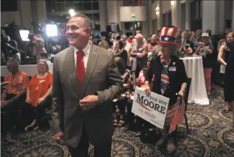  ?? Scott Olson / Getty Images ?? Roy Moore greets guests after arriving at an election night rally in Montgomery, Ala. Moore, a former state chief justice, won a primary runoff contest against incumbent Sen. Luther Strange.