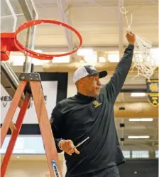  ?? ATLANTA JOURNAL-CONSTITUTI­ON PHOTO BY MIGUEL MARTINEZ VIA AP ?? Kennesaw State men’s basketball coach Amir Abdur-Rahim responds to fans as he holds the cut net after the Owls defeated Liberty in the ASUN Conference tournament final Sunday. With the championsh­ip, the Georgia program also earned its first trip to the NCAA Division I tournament.