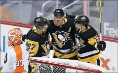  ?? KEITH SRAKOCIC — THE ASSOCIATED PRESS ?? Pittsburgh Penguins’ Evgeni Malkin, center, celebrates with Sidney Crosby (87), and Bryan Rust (17) after scoring on Philadelph­ia Flyers goaltender Brian Elliott (37) during the first period of an NHL hockey game, Saturday in Pittsburgh.