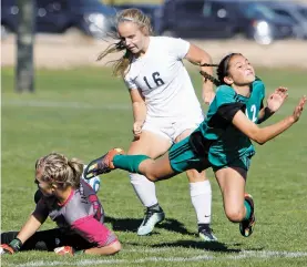  ?? LUIS SÁNCHEZ SATURNO/THE NEW MEXICAN ?? Prep’s Lynn Robey, center, takes back the ball for a shot after Moriarty’s goalkeeper takes out her own defender Maranda Apodaca, right.