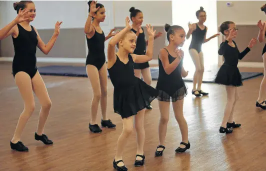  ?? Photos by Lisa Krantz / Staff photograph­er ?? Halloween music plays at Studio C dance school in Floresvill­e last Monday as Evelyn and her classmates warm up for their tap and ballet class.