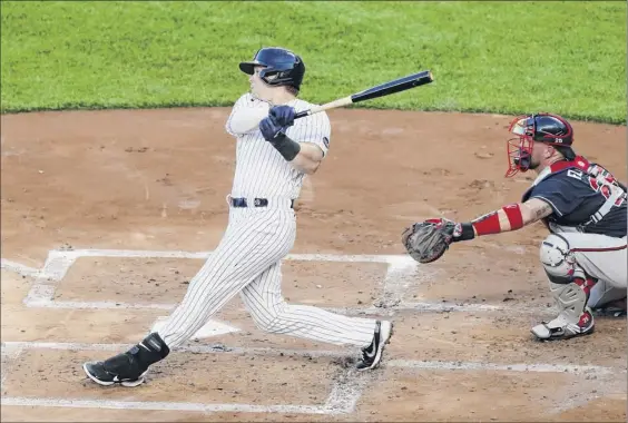  ?? Photos by Kathy Willens / Associated Press ?? Yankees first baseman Luke Voit hits a three-run home run during the first inning against the Braves on Tuesday night at Yankee Stadium.