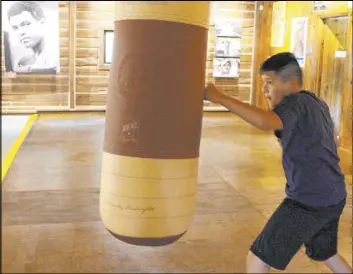  ?? Michael Rubinkam The Associated Press ?? Benny Quiles-Rosa punches the heavy bag in the gym Saturday at Fighter’s Heaven, Muhammad Ali’s training camp in Deer Lake, Pa. The newly renovated camp is open to the public on weekends.