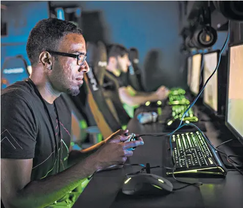  ??  ?? Video game players do battle in a Belong arena within Game Digital’s store in Soho, London. The chain now has 18 of the facilities across the country