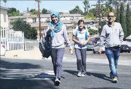  ?? Frederic J. Brown/AFP/Getty Images ?? Syrian refugee Ammar Kawkab, right, and his daughters Noor, center, and Aya make their way home from school last month in San Diego. The United States has taken in 10,000 Syrian refugees in 2016 as part of a resettleme­nt program.