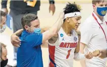  ?? MICHAEL CONROY/AP ?? Florida guard Tre Mann and head coach Mike White celebrate while leaving the court following the Gators’ overtime win Friday.