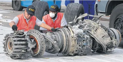  ??  ?? Officials inspect the engine of the crashed Lion Air jet on Nov 4, 2018 in Jakarta. The final accident report found the pilots were never told how to quickly respond to malfunctio­ns of the Boeing 737 Max 8 jet’s automated flight-control system.