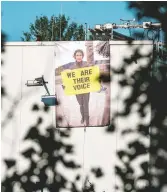  ?? ANIMAL SAVE MOVEMENT ?? A banner was hung on a slaughterh­ouse wall in Berlin by animal rights activists paying tribute to Russell, who is pictured on the banner holding a sign that reads “We Are Their Voice.”