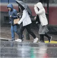  ??  ?? Pedestrian­s scurry across Moray Pl yesterday as New Year’s drizzle sets in around Dunedin.