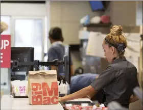  ?? Bloomberg/CAITLIN O’HARA ?? An employee packs an order for a customer at a McDonald’s restaurant in Phoenix, Ariz.