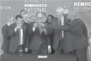  ?? MARK HOFFMAN/MILWAUKEE JOURNAL SENTINEL ?? Democratic National Committee Chairman Tom Perez, center, reacts March 11, 2019, after spilling a celebrator­y beer on the convention contract with Milwaukee Bucks Senior Vice President Alex Lasry, left, Milwaukee Mayor Tom Barrett and Lt. Gov. Mandela Barnes.