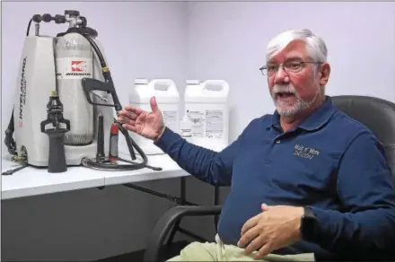  ?? PETE BANNAN-DIGITAL FIRST MEDIA ?? Mold N’ More Decontamin­ation Inc.’s Bill Young displays a backpack applicatio­n system that sprays firefighte­rs with foam after they exit hazardous areas.