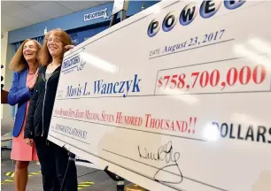  ?? AP ?? Mavis Wanczyk stands by a poster of her winnings during a news conference where she claimed the $758.7m Powerball prize at Massachuse­tts State Lottery headquarte­rs in Braintree. —