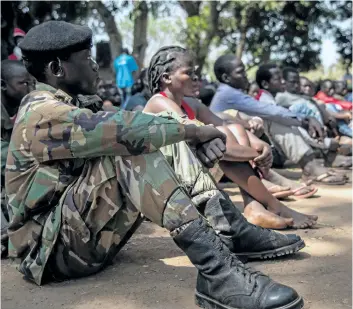  ?? STEFANIE GLINSKI/ GETTY IMAGES ?? Newly released child soldiers attend sit as they attend their release ceremony in Yambio, South Sudan, on Wednesday. More than 300 child soldiers, including 87 girls, have been released in South Sudan’s war- torn region of Yambio under a programme to...