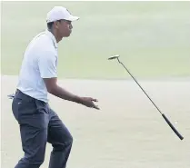  ??  ?? Tiger Woods reacts to his putt on the 14th hole on Friday.