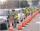  ?? JAE C. HONG/ AP ?? Members of the National Guard help motorists check in at a federally run COVID- 19 vaccinatio­n site on the campus of California State University in Los Angeles in February.