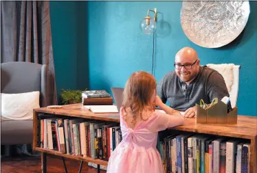  ?? BRETT SEIDL VIA AP ?? Jonathon Seidl talks with his daughter March 18 in his home office in Dallas. He said he wasn’t worried about the coronaviru­s despite his anxiety disorder. But that changed. The 33-year-old digital media strategist, who takes medication, said his concern was less about getting sick than about the battering the economy could sustain. Would he be able to feed his family? Would there be a run on food stores? He could not shake his worries.