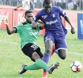  ?? LIONEL ROOKWOOD/PHOTOGRAPH­ER ?? Kingston College’s (KC) Damion Williams (right) is tackled hard by Calabar’s Andre Channer during their ISSA/Digicel Manning Cup encounter on September 18. KC won 3-0. Calabar bounced back with a 1-0 win over Clan Carthy yesterday.