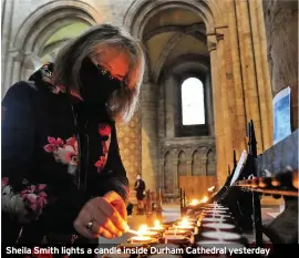  ??  ?? Sheila Smith lights a candle inside Durham Cathedral yesterday