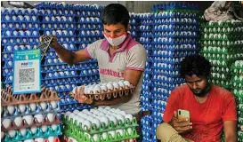  ?? (AFP) ?? Men work at a poultry shop where a QR code for Paytm is displayed in Mumbai on December 15, 2021