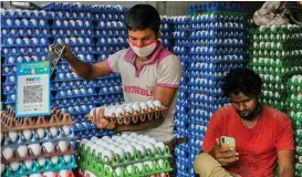  ?? (AFP) ?? Men work at a poultry shop where a QR code for Paytm is displayed in Mumbai on December 15, 2021