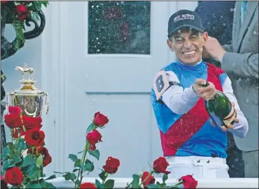  ?? (AP/Brynn Anderson) ?? Jockey John Velazquez sprays champagne May 1 after winning the 147th running of the Kentucky Derby on Medina Spirit at Churchill Downs in Louisville, Ky. On Friday, The Associated Press reported on stories circulatin­g online incorrectl­y claiming Velazquez turned down a White House invite saying that if he wanted to see a horse’s behind he would have come in second place.