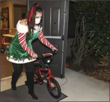  ?? The Sentinel-Record/Grace Brown ?? NEW BIKE: Morgan Stidham wheels out a bicycle to be given to a family during the Miracle on McAuley Court Christmas Program Distributi­on Night at Lake Valley Community Church, 910 Shady Grove Road, last Thursday.