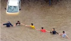  ??  ?? People make their way through a flooded street during heavy rains in Mumbai on Tuesday.