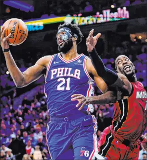  ?? Matt Slocum The Associated Press ?? 76ers center Joel Embiid and Heat center Bam Adebayo battle for the ball during Philadelph­ia’s 99-79 Game 3 victory Friday.