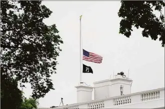  ?? Susan Walsh / Associated Press ?? The American flag flies at half-staff at the White House on Thursday, as the Biden administra­tion commemorat­es 1 million American lives lost due to COVID-19.