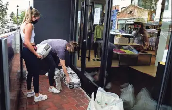  ?? Erik Trautmann / Hearst Connecticu­t Media ?? Employees of LuLu Lemon prepare for flooding ahead of Hurricane Henri Saturday in Westport.