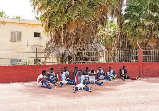  ??  ?? Ancora i giocatori della Spes Academy, sulla pista di atletica dello stadio Iba Mar Diop, mentre si riposano all’ombra delle palme.