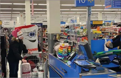  ?? PHOTO PROVIDED ?? Gretchen Cantwell (left), who serves as director of operations for Westside Donuts Albany, a Dunkin’ franchisee network, and Dunkin’mascot Cuppy right purchase toys during the annual Toys for Tots shopping spree on Tuesday at Walmart in Albany. The shopping spree will supply hundreds of toys for children in need and is a continuati­on of support fromCapita­l Region Dunkin’ franchisee­s during a holiday season challenged by the global health pandemic.