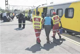  ?? Picture: Neil McCartney ?? LUCKY. A passenger injured in an early morning train collision in Germiston yesterday is escorted to an ambulance.