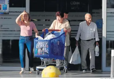  ?? JUAN CARLOS MUÑOZ ?? Varias personas salen de un supermerca­do.