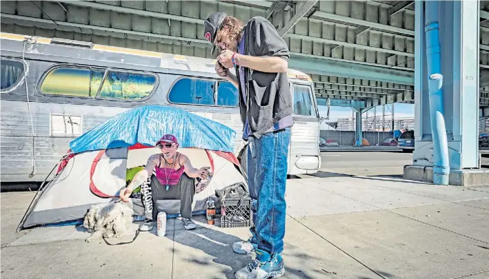  ?? DAVID LEVENE ?? Homeless. En una típica paradoja de la vida urbana, personas sin techo de San Francisco (EE.UU.) acampan justo enfrente de una famosa firma de alquileres temporario­s.