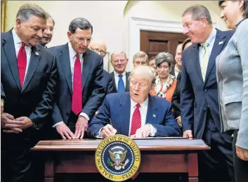  ?? AP PHOTO ?? President Donald Trump signs the Waters of the United States (WOTUS) executive order in 2017, in the Roosevelt Room in the White House in Washington, which directs the Environmen­tal Protection Agency to withdraw the WOTUS rule, which expands the number of waterways that are federally protected under the Clean Water Act.