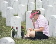  ??  ?? Nina Dulacki visits the grave of her parents, Edward and Antoinette Dulacki, on Saturday at Fort Logan National Cemetery.