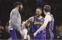  ?? AP photo ?? Lakers guard D’Angelo Russell (center) celebrates with Anthony Davis and Austin Reaves after making a 3-pointer during the second half Friday.